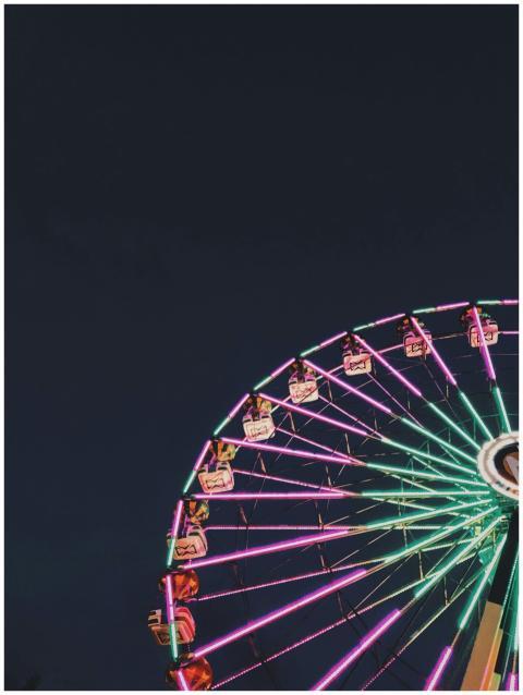 Colorful ferris wheel glowing in the night sky, ca