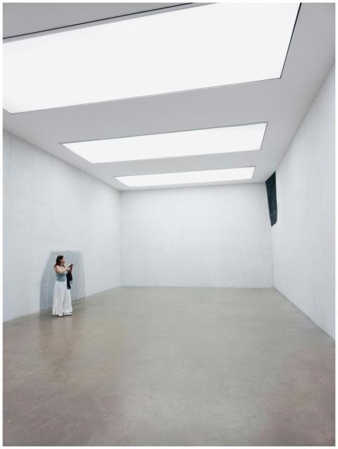 A minimalist indoor gallery with a visitor observi