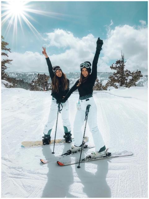 Two women posing on a snowy slope, enjoying a brig