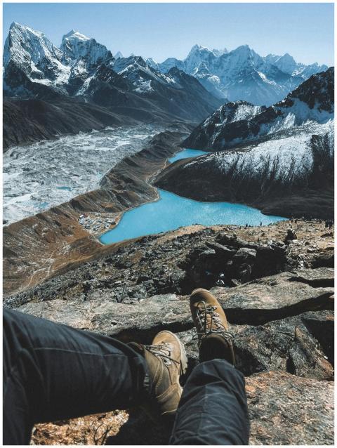A hiker's boots overlook the pristine Gokyo Lakes