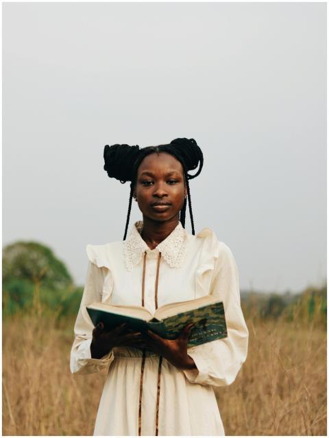 A serene portrait of a woman standing in a field h