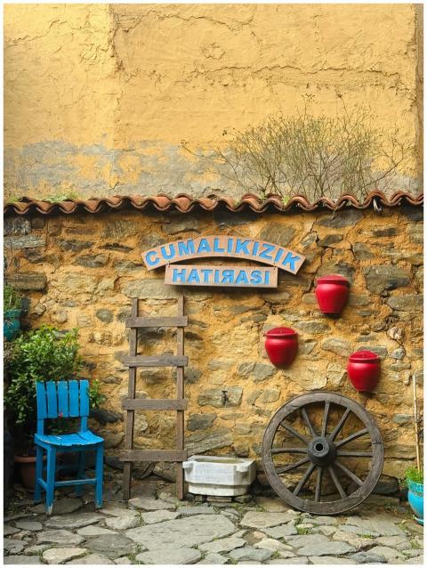 Charming rustic wall with pots and a wheel in Cuma