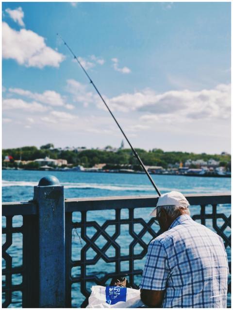 An elderly man fishing on Galata Bridge in Istanbu