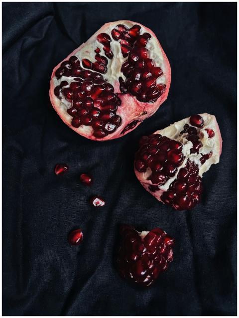 Close-up of a ripe pomegranate on a black backgrou