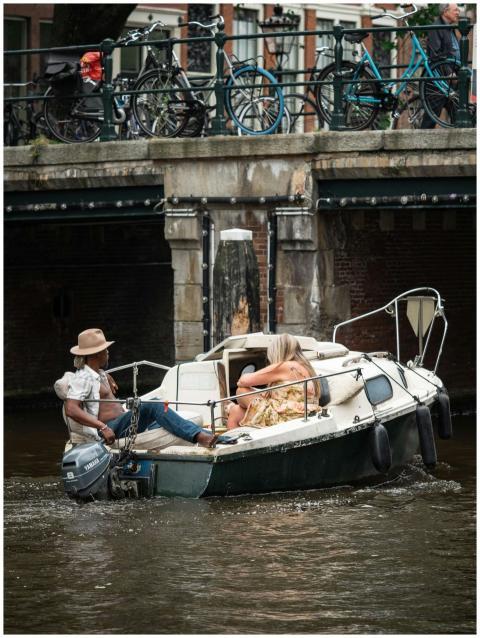 Two adults enjoy a relaxed boat ride on Amsterdam'