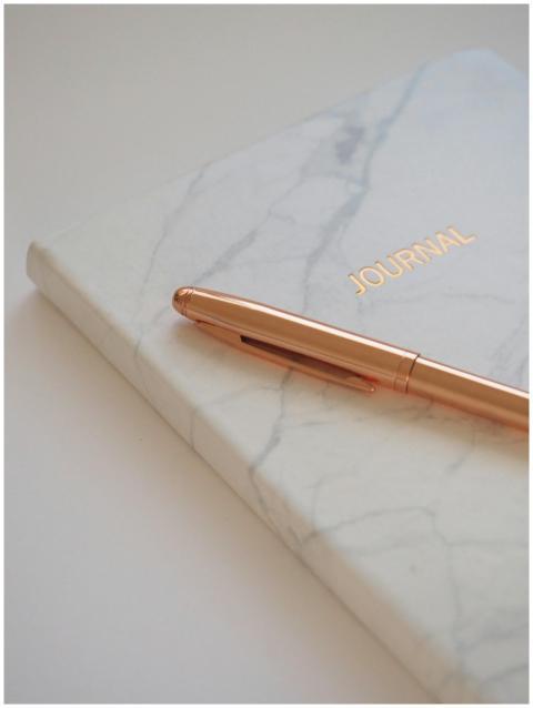 Minimalist marble journal with a gold pen, perfect