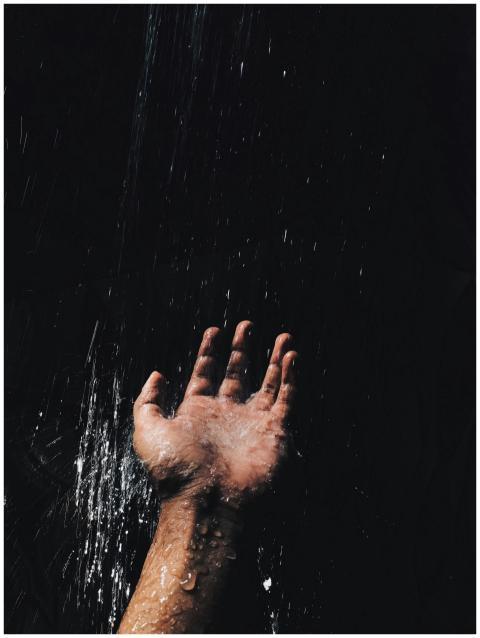 A dramatic image of a hand catching water against