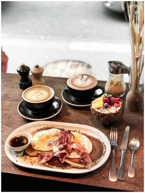 A delicious breakfast featuring pancakes, eggs, ba