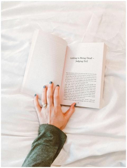Close-up of a woman's hand holding a book while re