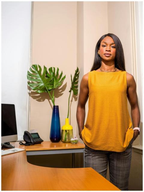 Stylish woman stands confidently in a modern offic