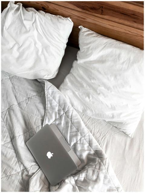 A comfortable bedroom scene with a laptop on a bed