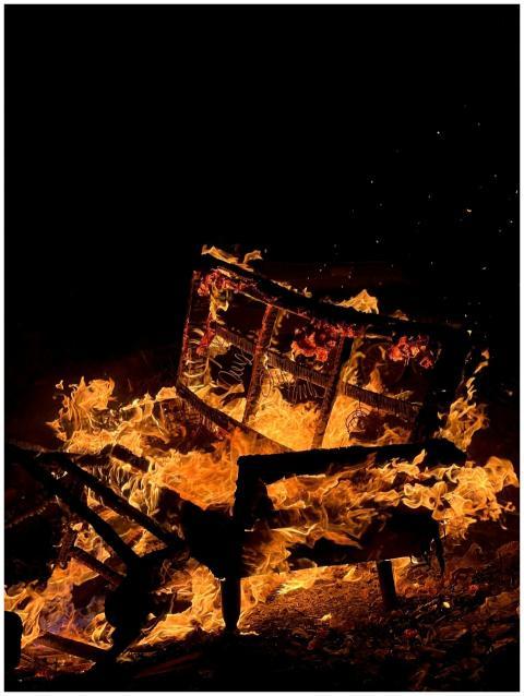 Dramatic shot of a wooden structure engulfed in fl