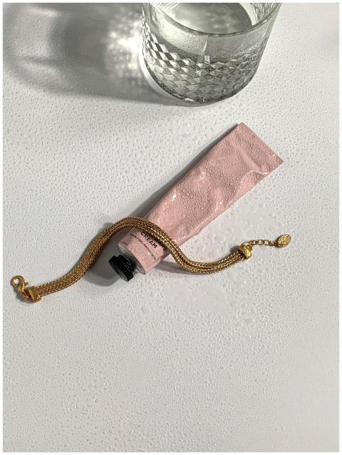 Minimalist still life featuring a gold bracelet, c