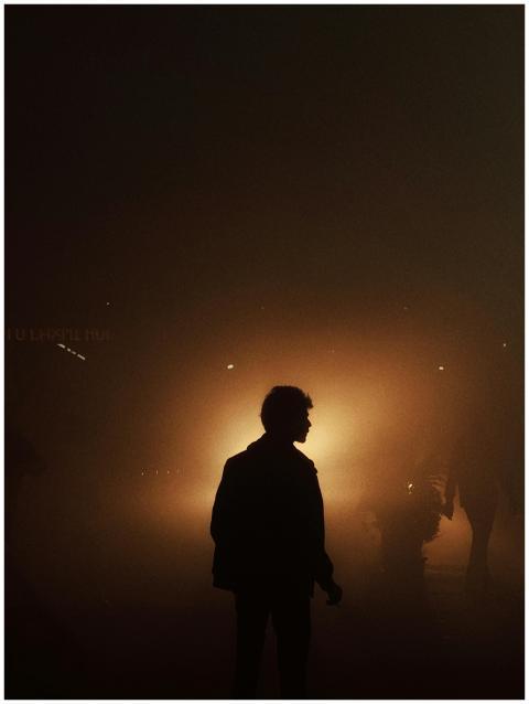 A silhouetted figure amidst a foggy scene, illumin