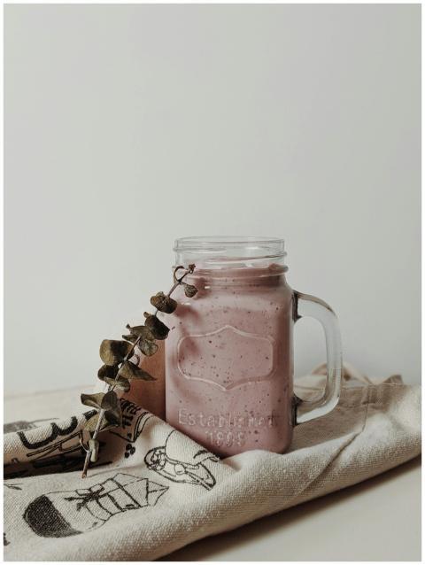 A rustic smoothie in a mason jar with eucalyptus o