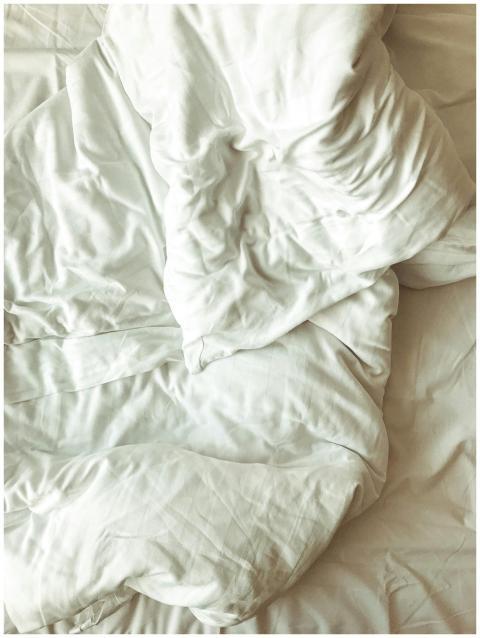 Close-up of soft, wrinkled white bed linen in a su