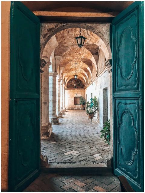 Rustic architectural corridor view through green d