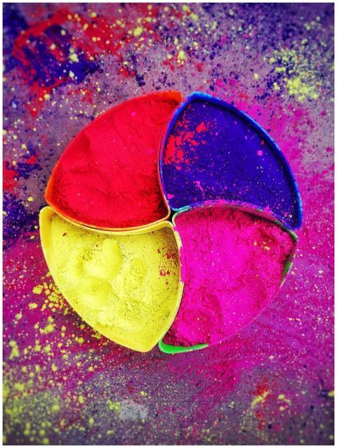 Vibrant Holi powder in colorful segmented dishes,
