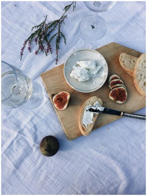 A rustic scene featuring cheese, figs, and bread o