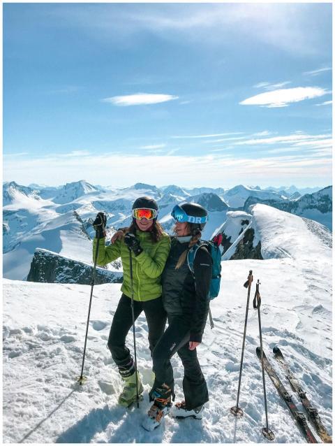 Two skiers enjoy a sunny winter day on a snowy mou