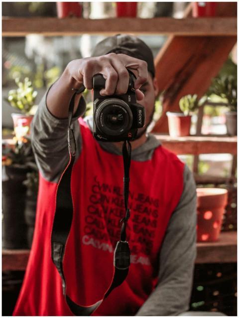 Young photographer capturing an image in a garden.