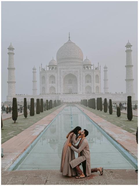 A romantic couple kissing in front of the iconic T