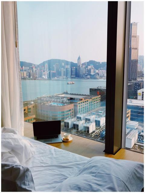 Cozy hotel room with cityscape view from bed, feat