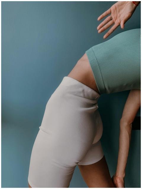 Close-up of a woman in athletic wear stretching ag