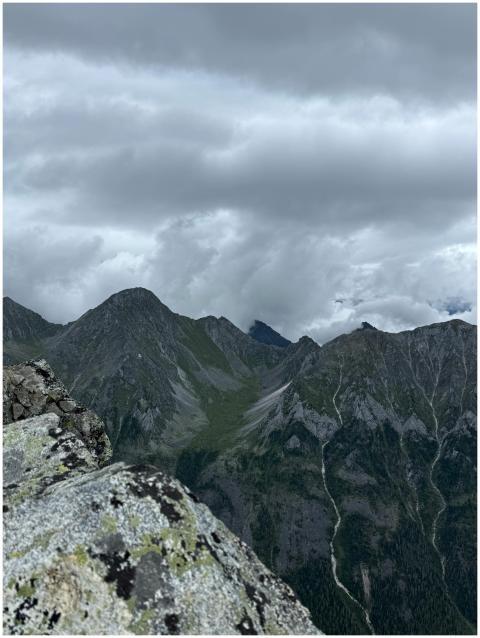 Scenic view of rugged mountains with looming cloud