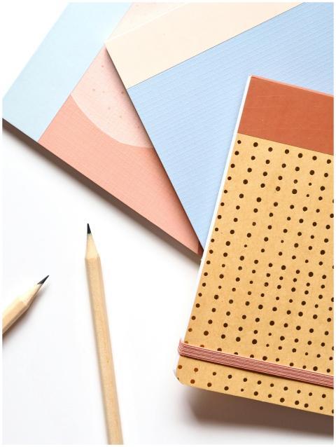 Colorful notebooks and pencils arranged neatly for