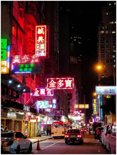Bustling night street in Hong Kong illuminated by