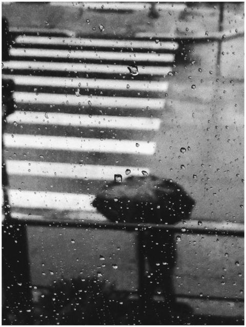 Monochrome view of raindrops on glass with a figur