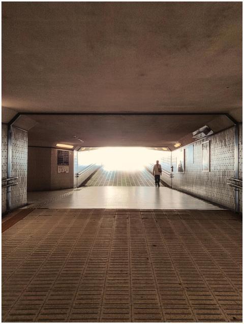 A lone pedestrian in a dramatic, well-lit Tokyo tu