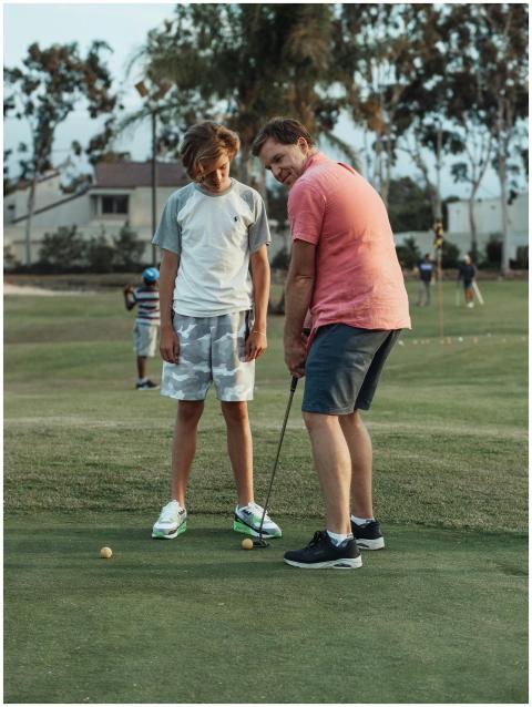 Father and son enjoy a day at the golf course, pra