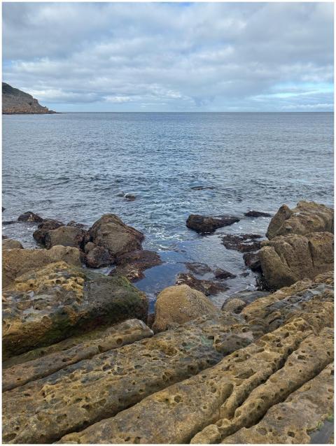 Rocky coastal view with dramatic clouds and serene