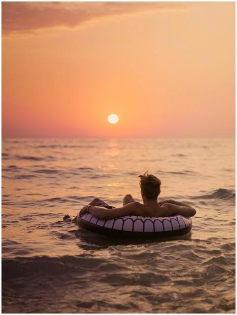 Back view of unrecognizable male tourist lying in