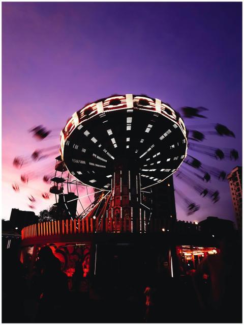 A vibrant swing ride in motion during dusk at an a