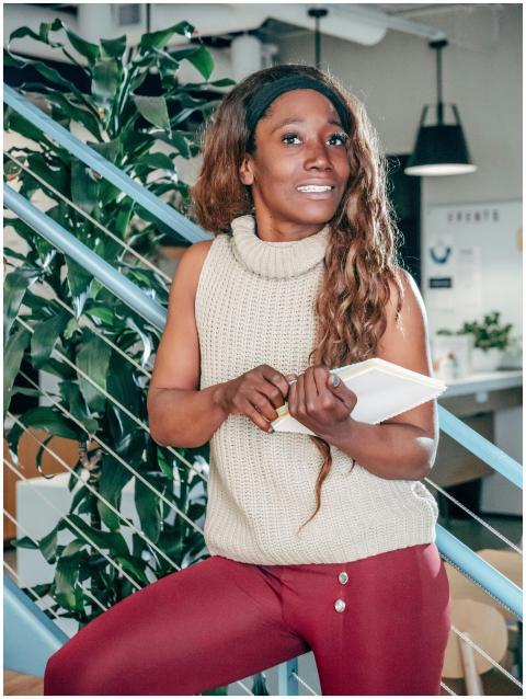 African American woman smiling while holding a not