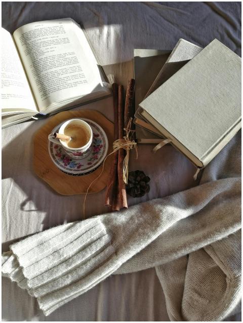 A warm setting featuring books, coffee, and a swea