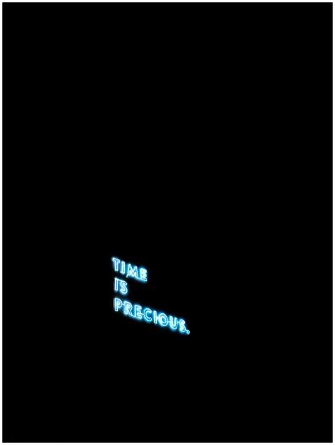 A glowing neon sign on a black background reads 'T