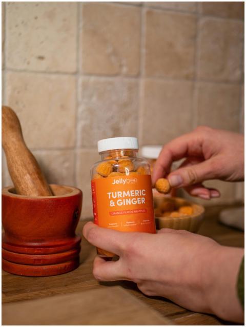 Hands holding Jellybee turmeric and ginger gummies