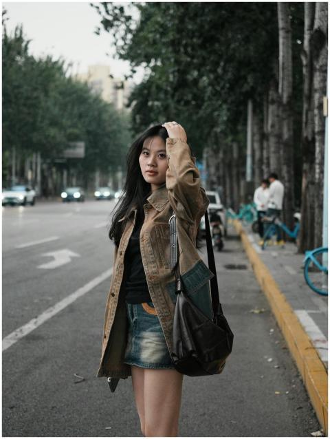 Casual street portrait of a young woman walking al
