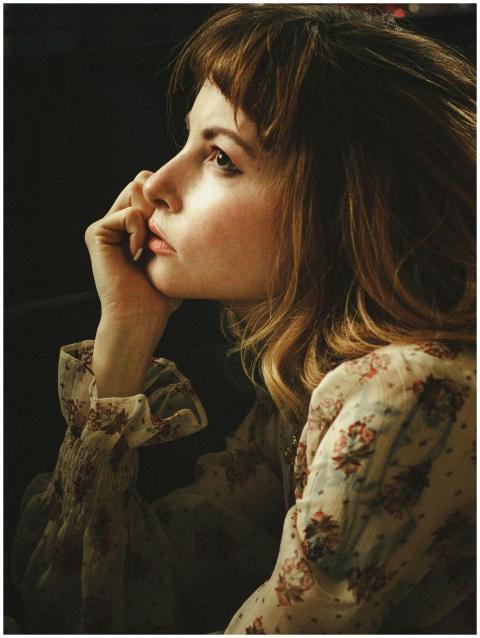 A thoughtful woman in a vintage floral dress, capt