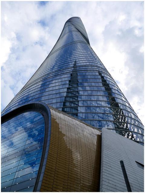 Modern skyscraper reflecting clouds with unique ar