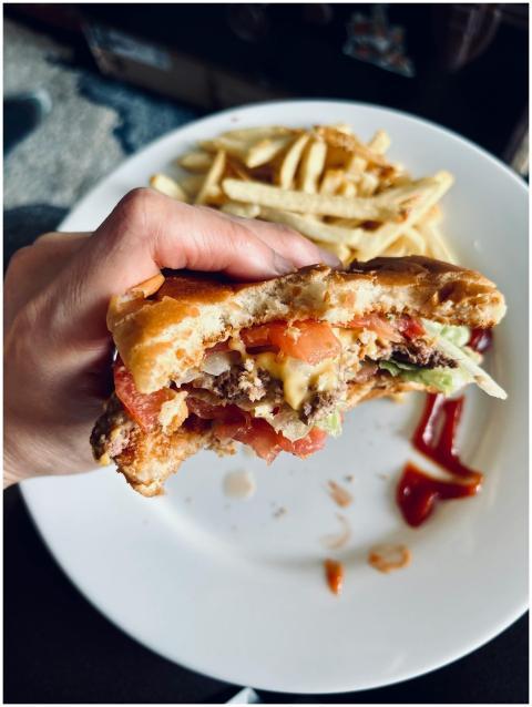 A delicious cheeseburger with toppings and a side