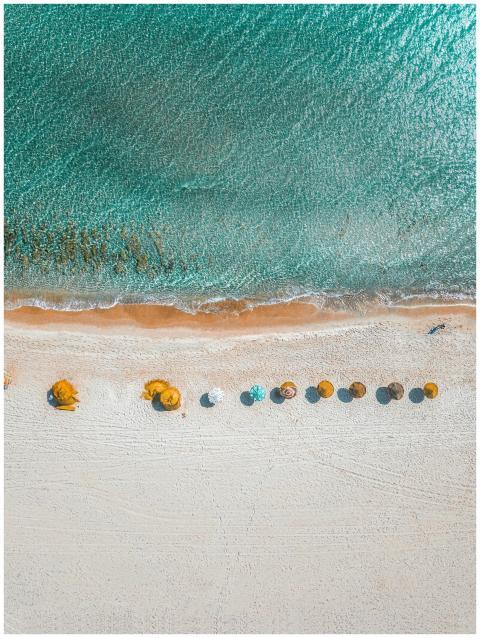 Aerial view of vibrant beach umbrellas on the shor