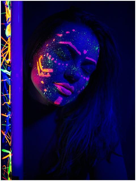 Portrait of a woman with glowing neon paint under