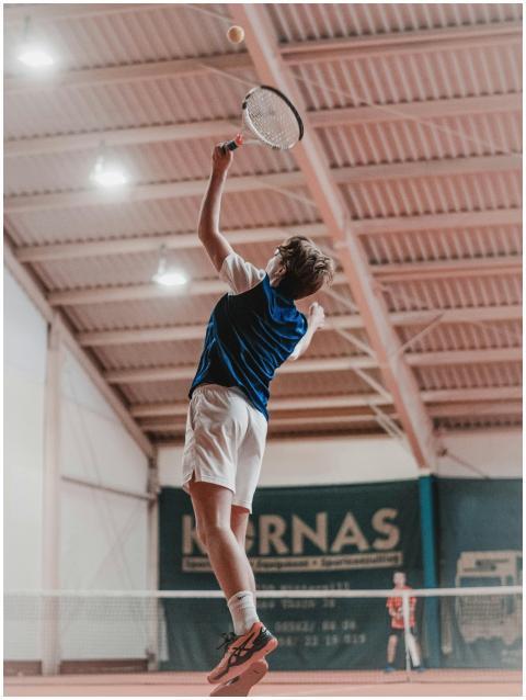 A tennis player jumps to hit the ball during an in