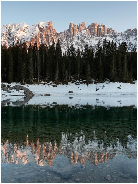Serene winter landscape of conifer forest reflecti