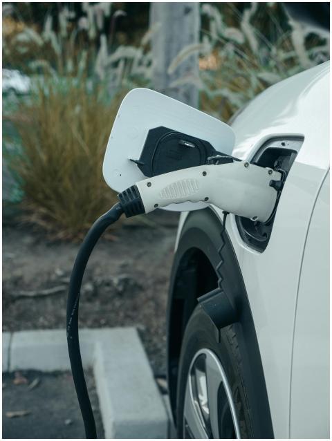 Close-up of electric vehicle connected to charging